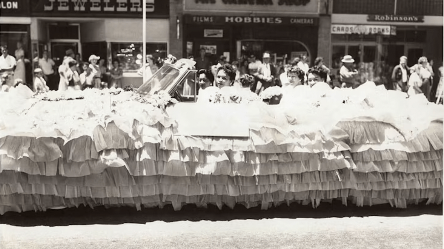 alt="Women sitting in parade float.">